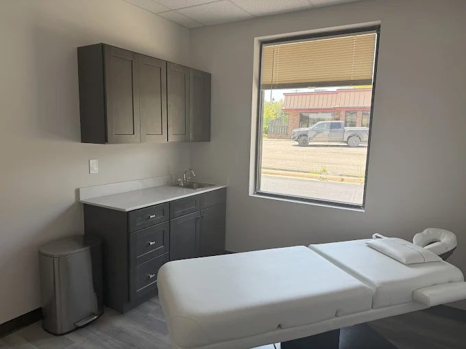 Exam room at Sylvan Lake Family Practice with a cushioned exam table and cabinetry
